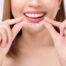 Smiling person holding clear aligners, highlighting cosmetic dentistry and oral health in Newnan.